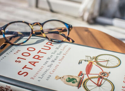 Picture of the book $100 Startup with a pair of glasses.