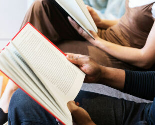 A woman and man sitting next to each other reading books. Image sourced from user burst on pexels.